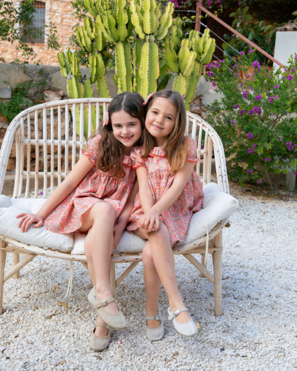 Dos niñas con vestidos florales a juego en tonos coral - Moda infantil artesanal para hermanas | Sutier