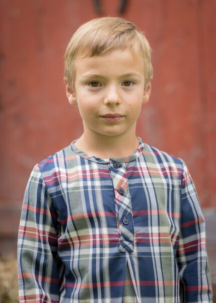 Polera para niño de la colección Miño, con estampado de cuadros y diseño versátil, perfecta para ocasiones especiales o el día a día.