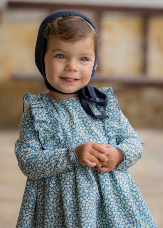Vestido de bebé en estampado de flores azules, perteneciente a la colección Asón de Sutier, ideal para ocasiones especiales y confort diario.