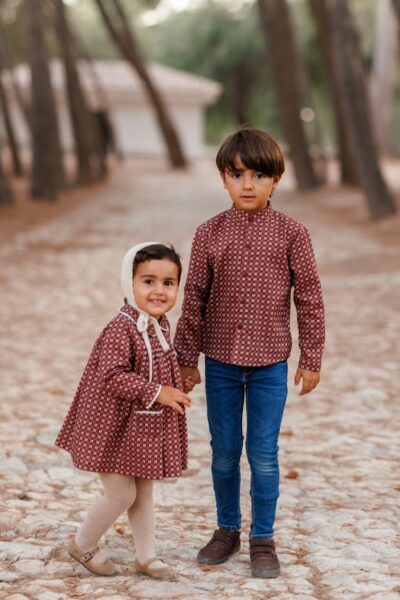 Hermanos vestidos con prendas de la colección Nalón, combinando estilo y comodidad con detalles artesanales y diseños elegantes.
