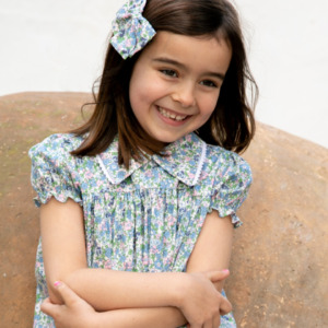 Vestido azul con estampado floral y lazo en el cabello, diseño elegante y fresco de Sutier.