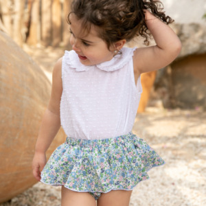 Blusa blanca infantil combinada con falda floral azul de vuelo, moda encantadora de Sutier.