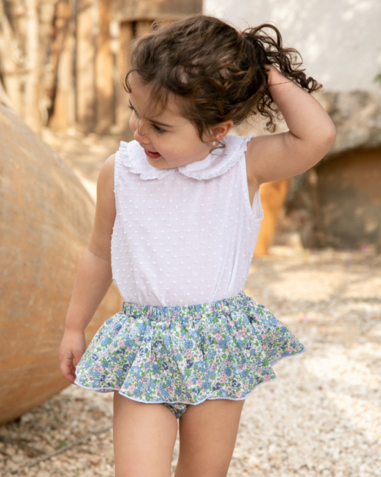 Blusa blanca infantil combinada con falda floral azul de vuelo, moda encantadora de Sutier.