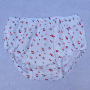 Pantalón corto con flores rojas de la colección Montañesa, sobre fondo blanco.