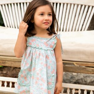 Niña con vestido floral de tirantes y bolsillos, moda infantil fresca de la colección Samba