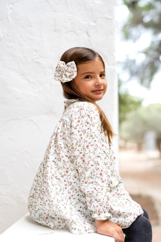 Niña con vestido floral blanco y lazo a juego en el pelo, moda infantil Sutier