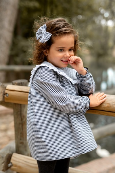 Niña con vestido infantil de cuadros vichy en blanco y negro con lazo a juego de Sutier