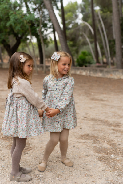 Dos niñas con vestidos florales de manga larga en tonos suaves, moda infantil de Sutier