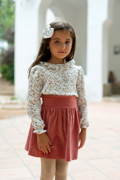Niña con falda coral y blusa floral blanca de manga larga, ropa infantil Sutier