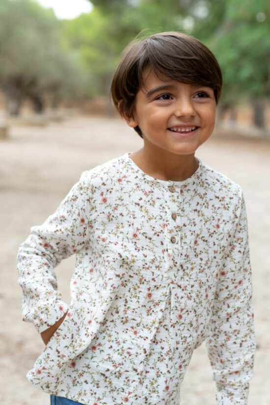 Niño sonriente con blusa floral blanca de manga larga, moda infantil Sutier