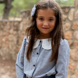 Blusa Nogal de niña en cuadros vichy azul y blanco con cuello bordado. Moda infantil artesanal hecha en España, cómoda, versátil y elegante para cualquier ocasión.
