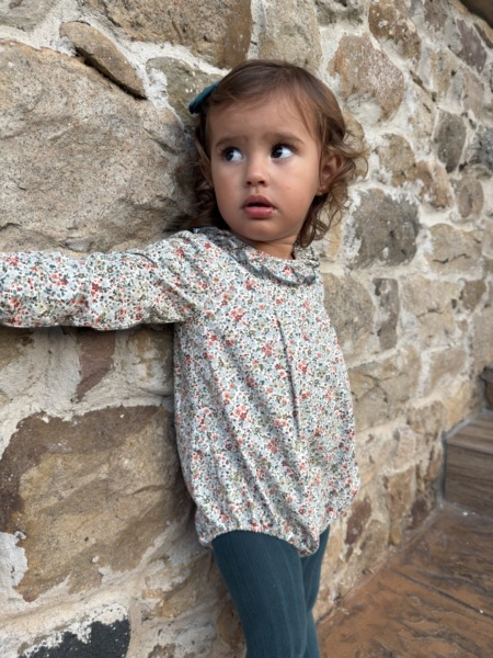 Bebé luciendo el Pelele Acebo de flores, moda infantil artesanal y versátil