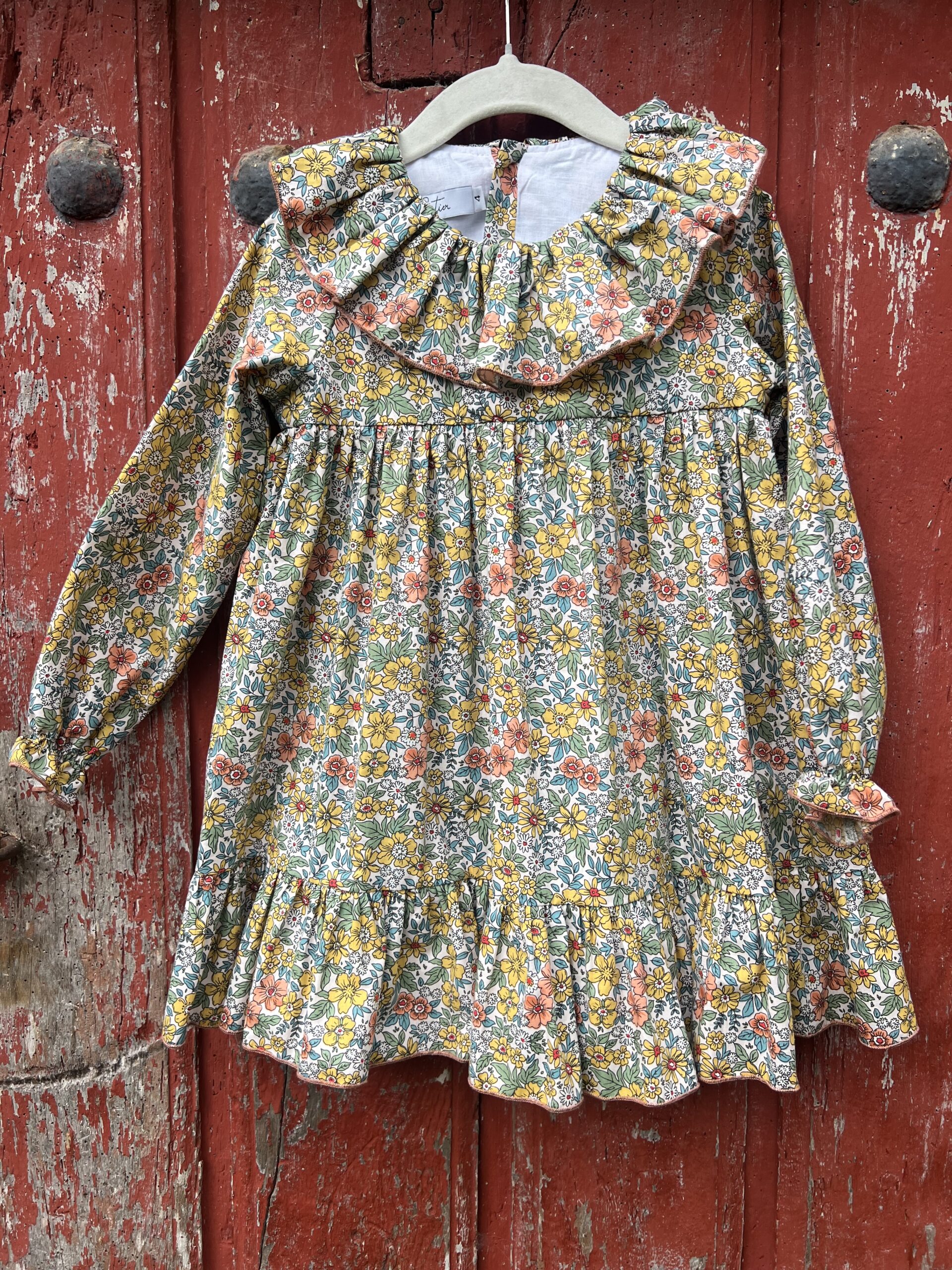 Jesusito de bebé Evelyne con estampado floral en mostaza, rosa y azul y cuello de volante